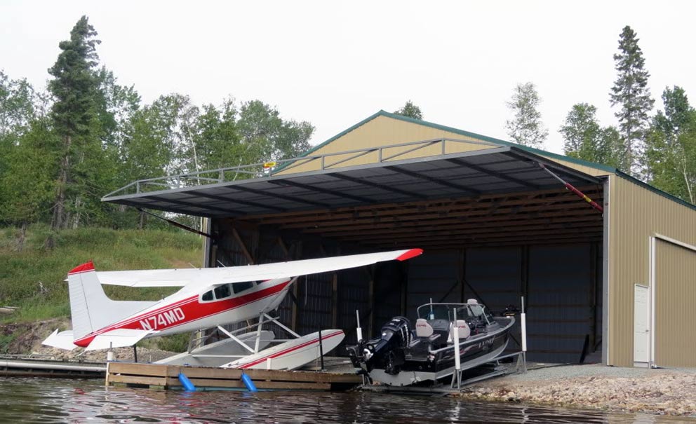 A sea plane being loaded into a waterside hangar